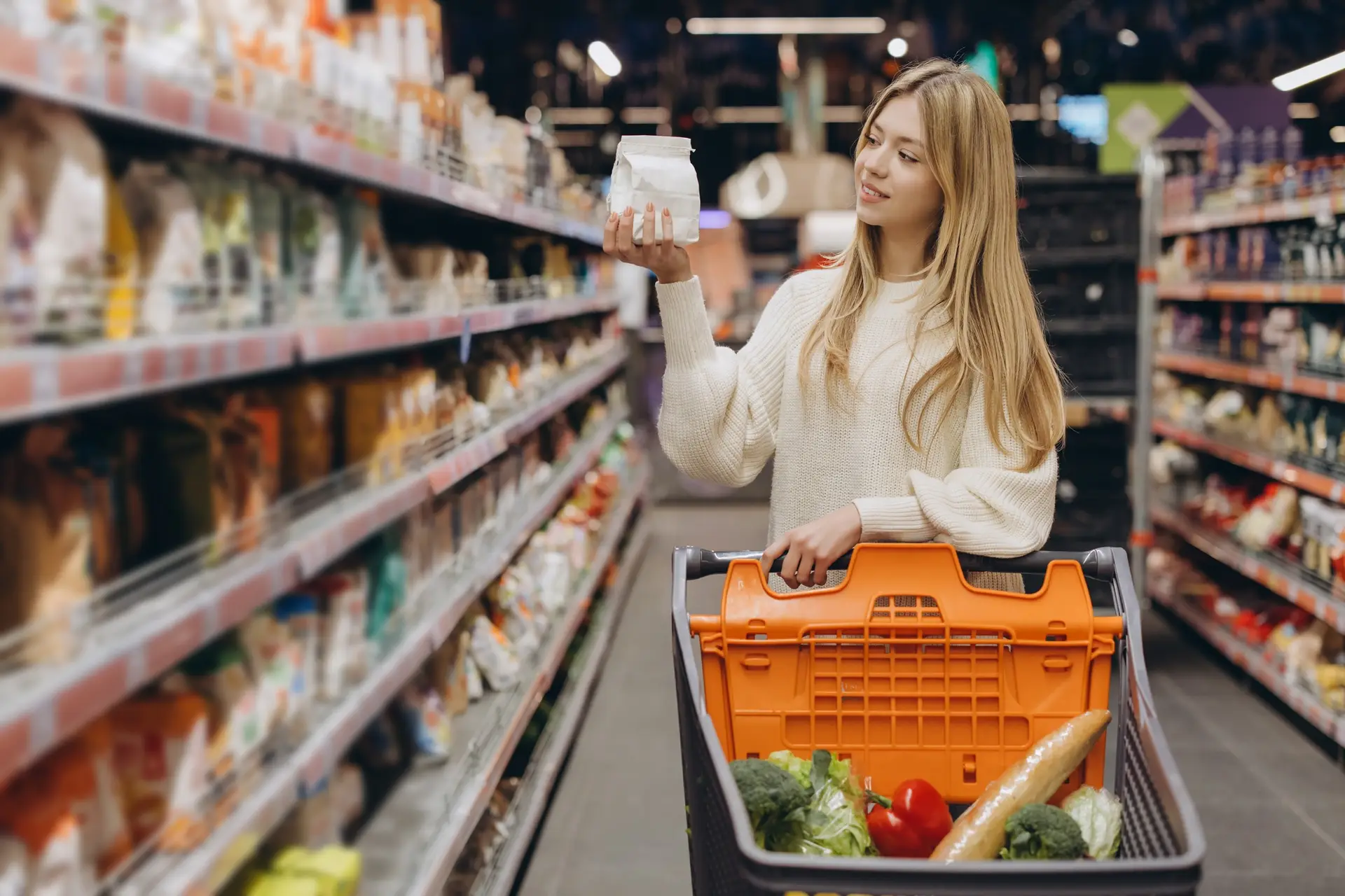 Customer choosing food product in supermarket reading label information