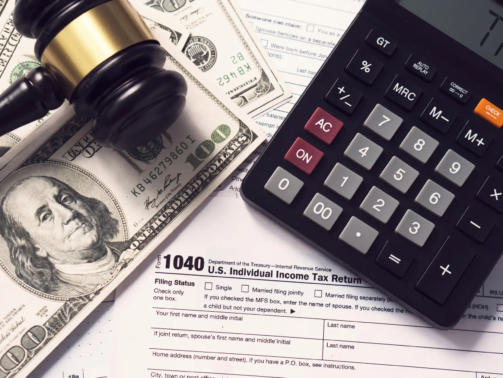 Tax concept.Calculator with taxes text with money on 1040 tax form.The new year tax concept.