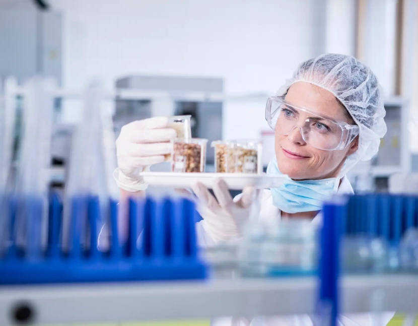 Scientist in lab examining seed samples